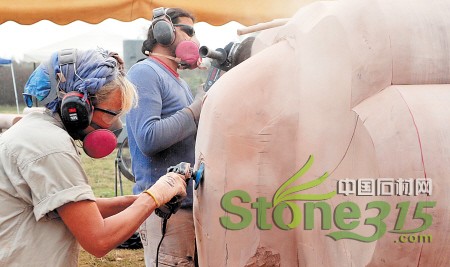 10月24日下午，美国雕塑家卡罗尔·特纳（左一）在忙碌。整天戴着口罩和护目镜，在机器的轰鸣声中和石料、粉尘打交道，雕塑家们每天的工作强度非常大。